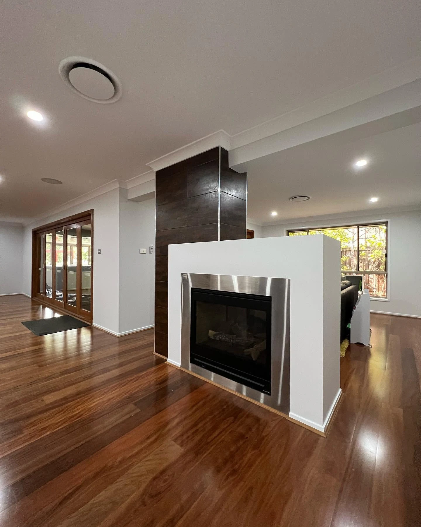 Light interior walls and ceiling around a fireplace and timber-framed doorway.